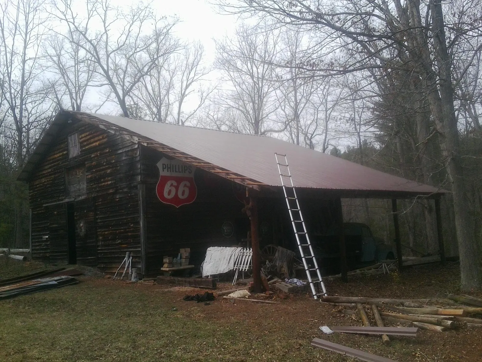 New metal roof on an open sided timber barn with a vintage sign in Pinson