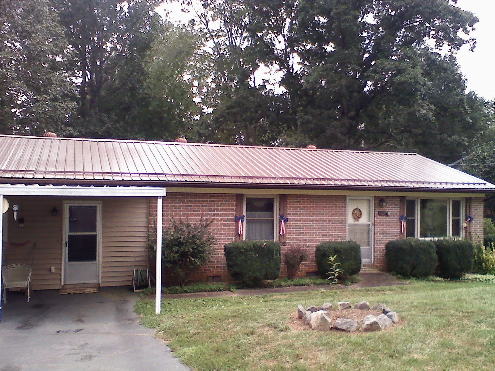 Bronze metal roof and carport on a brick ranch home — Roof Repair work by our crew in Pinson