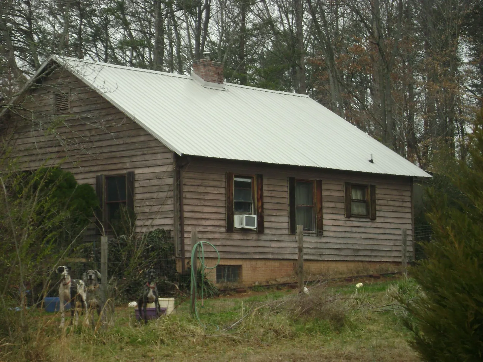 White metal roof on an old wood sided farmhouse, from a Metal Roof Installation job in Pinson